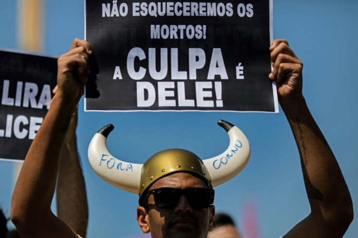 A man holds a sign reading "We won't forget the dead! It is his fault!" -- in allusion to President Jair Bolsonaro -- during a demonstration demanding his impeachment