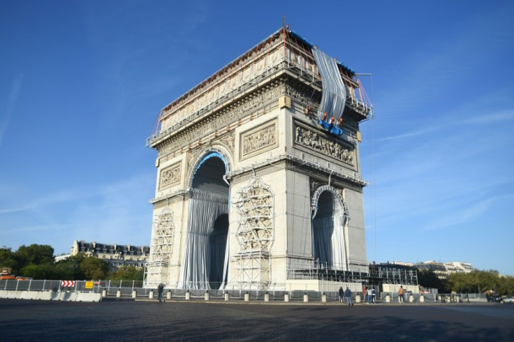 Workers begin the week-long process of wrapping the monument in silver-blue fabric