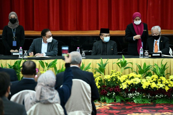 Prime Minister Ismail Sabri Yaakob (R) and representatives of the opposition, led by Anwar Ibrahim (2nd L), signed the agreement in parliament