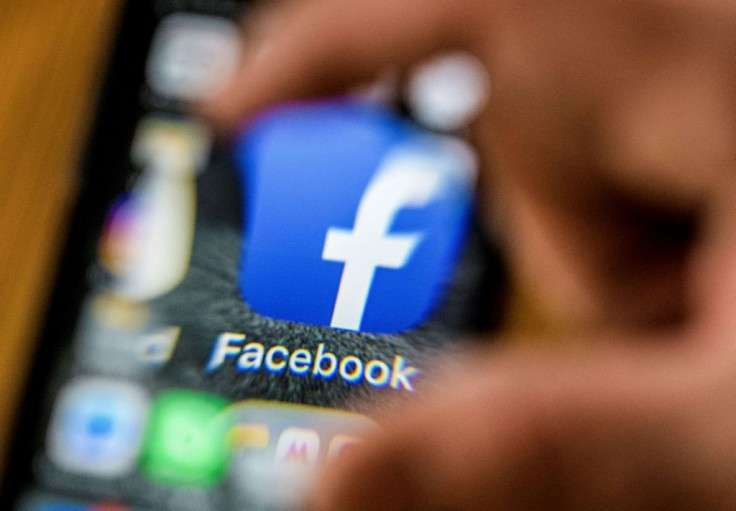 An illustration picture taken through a magnifying glass on March 28, 2018 in Moscow shows the icon for the social networking app Facebook on a smart phone screen. Facebook said on March 28, 2018 it would overhaul its privacy settings tools to put users "