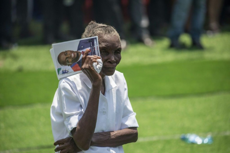 A woman holds a picture of slain Haitian President Jovenel Moise during his funeral on July 23, 2021, in Cap-Haitien, Haiti