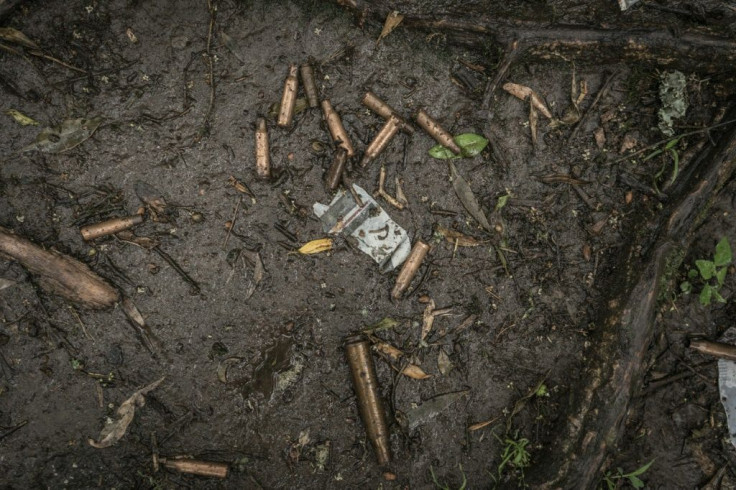 Spent bullet casings litter the ground near a mass grave in Chenna