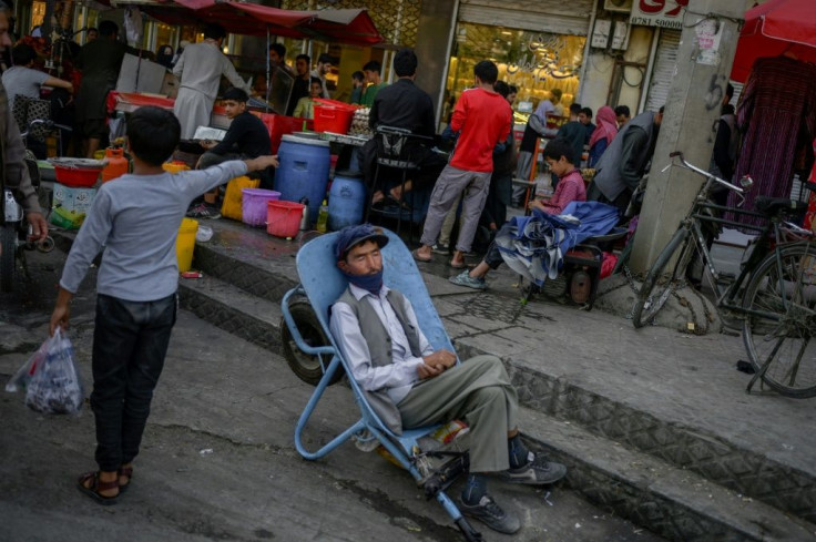 A man sleeps on a wheelbarrow at a market area in Kabul