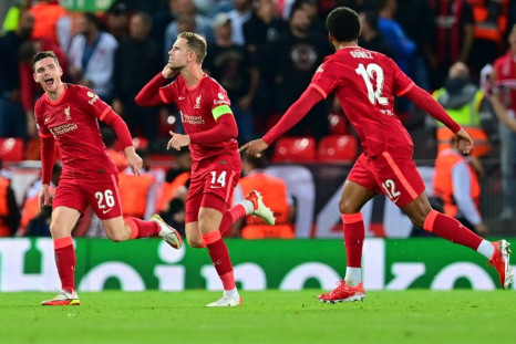 Jordan Henderson (C) celebrates with teammates after scoring his team's third goal during the UEFA Champions League 1st round Group B football match between Liverpool and AC Milan at Anfield in Liverpool, north west England on September 15, 2021.