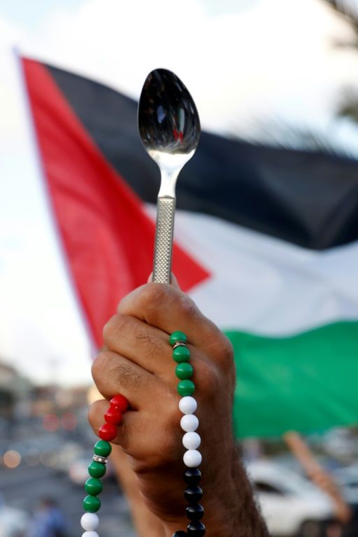 Arab Israeli protesters lift spoons during a demonstration in the mostly Arab city of Umm al-Fahm in northern Israel in September 2021