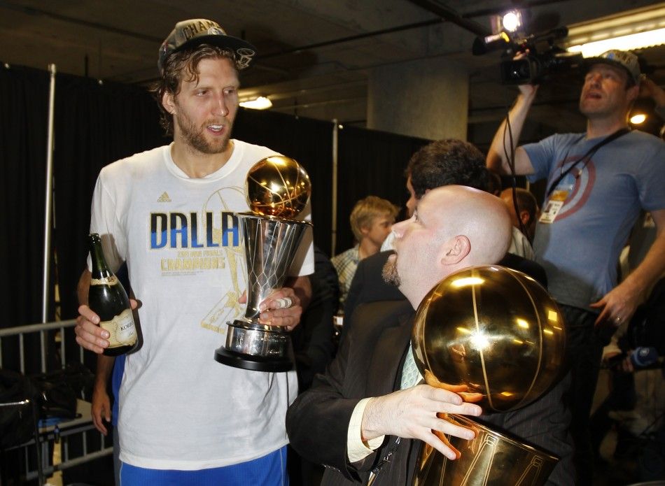Dallas Mavericks Dirk Nowitzki walks with his MVP trophy and a bottle of champagne after the Mavericks won the NBA Championship defeating the Miami Heat in Miami