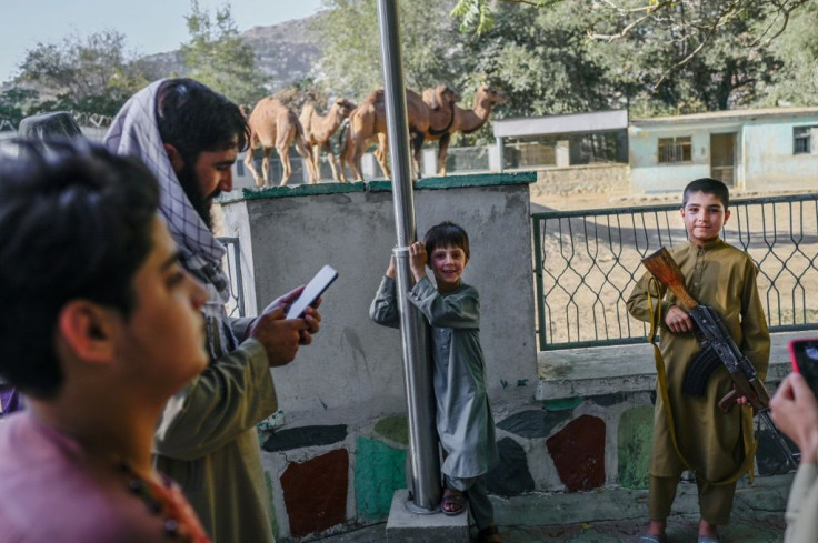 A group of Taliban gunmen offered their rifles to boys as young as eight, who took snaps with their mobile phones