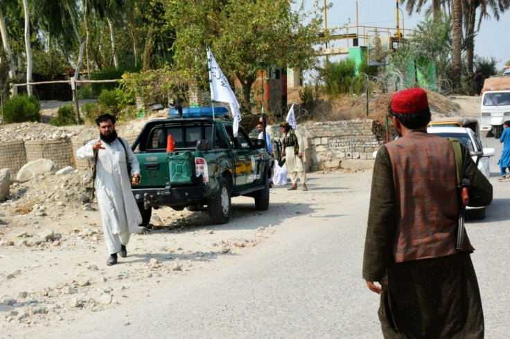 Taliban members inspect near the site of a blast in Jalalabad on September 18