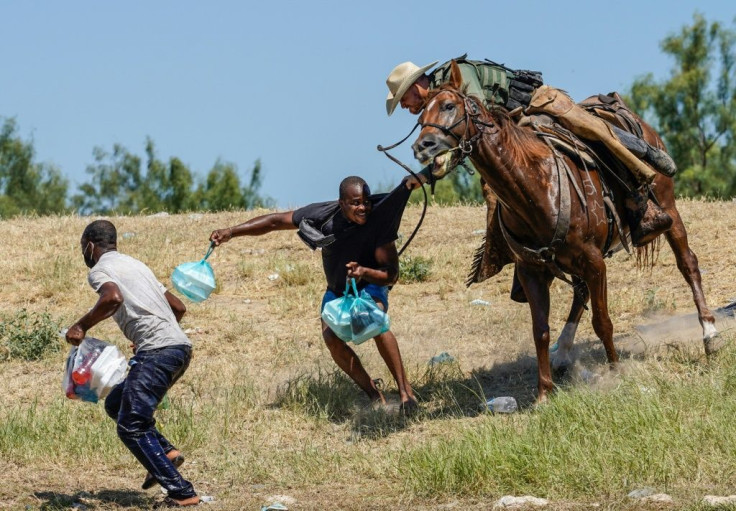 A United States Border Patrol agent on horseback tries to stop a Haitian migrant from entering an encampment on the banks of the Rio Grande near Del Rio, Texas.