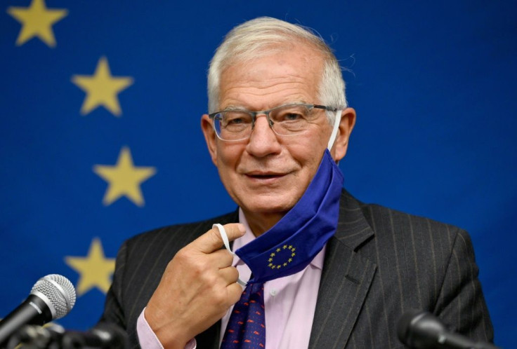 Top EU diplomat Josep Borrell removes his face mask prior to speaking during a press conference following a meeting at the United Nations of EU foreign ministers that touched on a US-French row