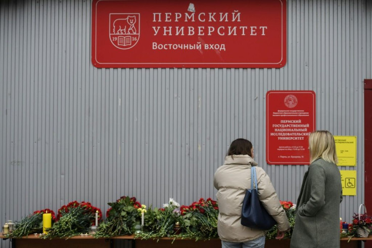 Mourners laid red carnations and lit candles at makeshift memorials around the university