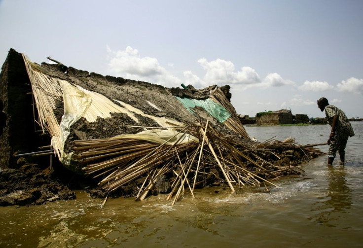 A South Sudanese refugee inspects a house damaged in floods in Al-Qanaa village in Sudan's southern White Nile state