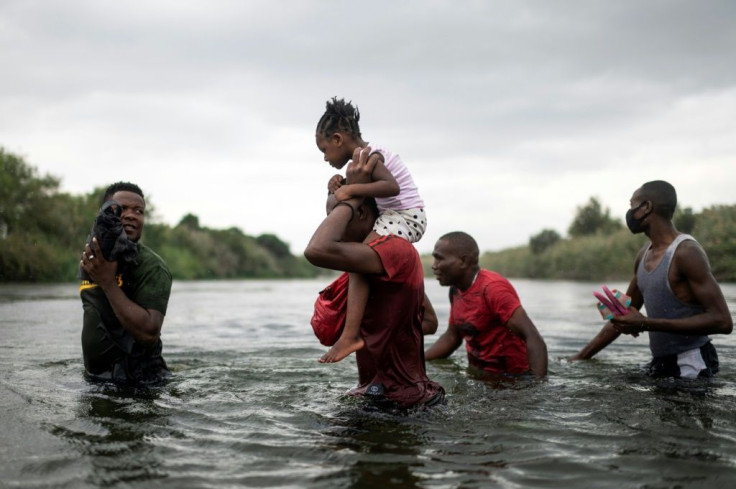 Haitian migrants stranded at the US border cross the Rio Grande river to get food and water in Mexico