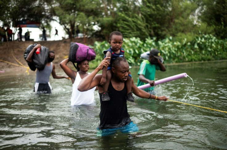 Migrants cross the Rio Grande holding onto ropes so they won't be swept away