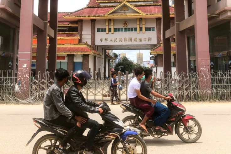 Motorists pass the China-Myanmar border gate in Muse in Shan state, as the Chinese city of Ruili near the frontier with Myanmar imposed a lockdown