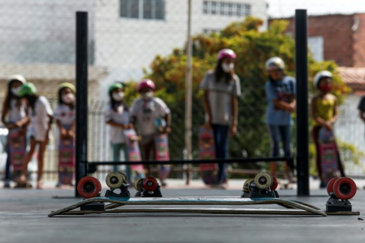 Young girls in Poa, a suburb of Sao Paulo, get ready to take their turn skateboarding