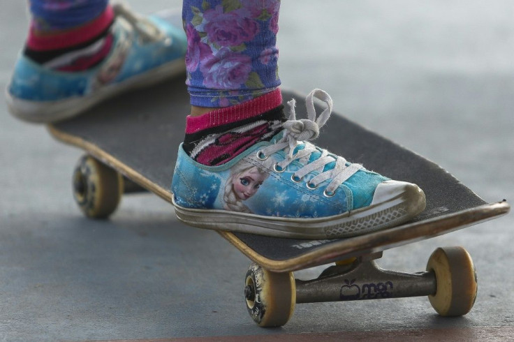 This young girl is wearing sneakers from the Disney movie "Frozen" as she skateboards