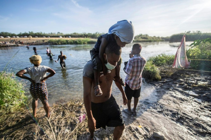 Haitian migrants hoping to enter the United States cross the Rio Grande river to get food and water in northern Mexico