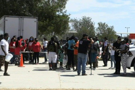 Migrants receive supplies from volunteers at camp on Mexico-US border