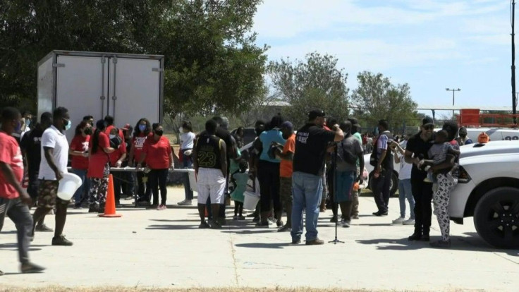 Migrants receive supplies from volunteers at camp on Mexico-US border