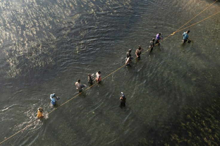 Haitian migrants to the United States cross the Rio Grande river from texas back to mexico to get food and water.