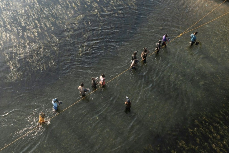 Haitian migrants to the United States cross the Rio Grande river from texas back to mexico to get food and water.