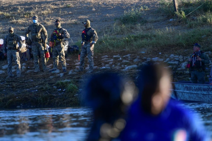 United States Border Patrol agents stand guard on the banks of the Rio Grande river at the border with Mexico