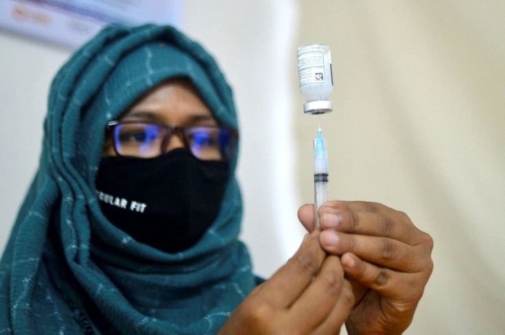A health worker prepares to inoculate a Bangladesh garment worker with a dose of the Moderna vaccine against the Covid-19