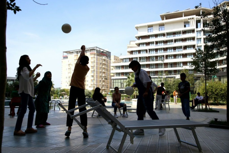 The anxiety of the adults chimes awkwardly with the sound of children playing ball games or jumping into the pool