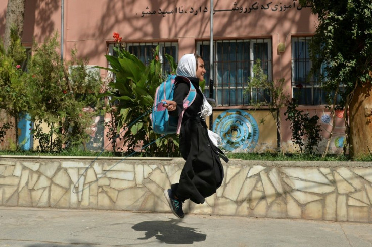 A young girl skips on a rope outside her primary school in Herat