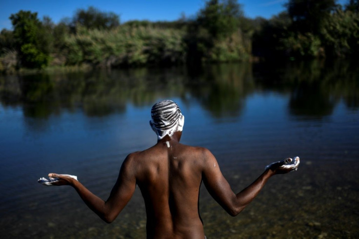 A Haitian migrant bathes in the Rio Grande river in Ciudad Acuna at the Mexican-US border