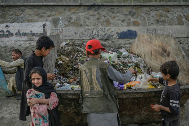 Children collect food and recyclables from a waste container near Kabul airport on September 21, 2021
