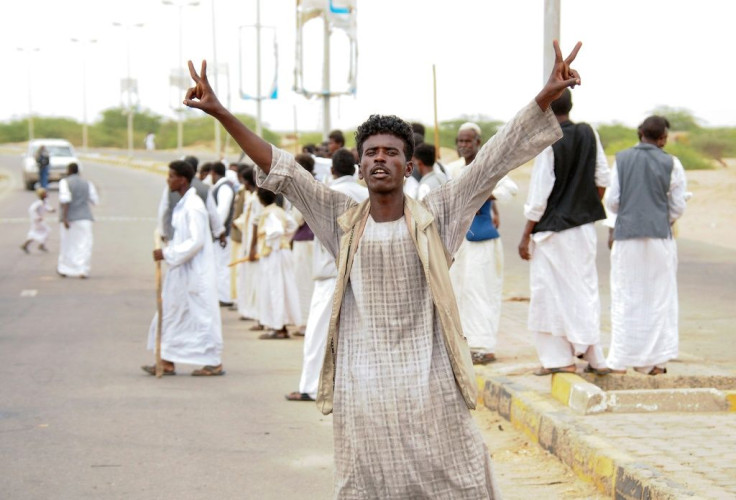 A protester flashes victory signs following the arrival in Port Sudan of a delegation led by a member of Sudan's ruling Sovereign Council on September 26, 2021