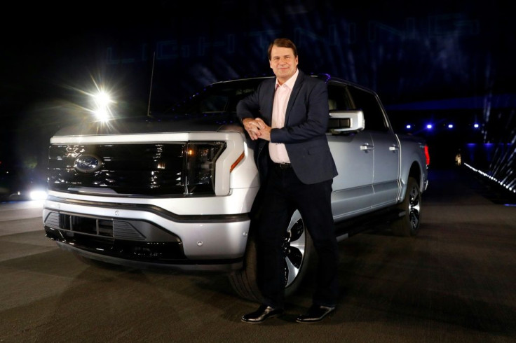 Ford Motor Company's CEO Jim Farley poses next to the newly unveiled electric F-150 Lightning outside of their Dearborn, Michigan headquarters in May 2021; he said the company seeks to deliver electric vehicles "for the many rather than the few"