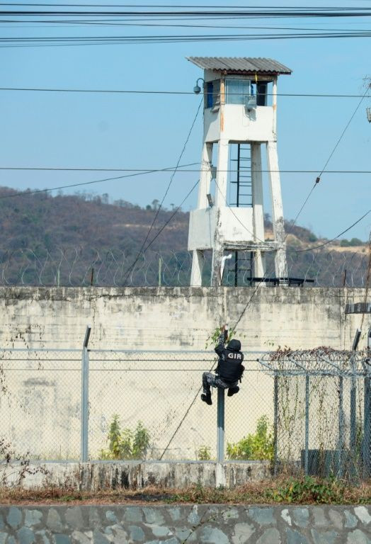 A riot police officer climbs the security fence as deadly violence broke out at the Guayaquil prison on September 28, 2021 in Ecuador