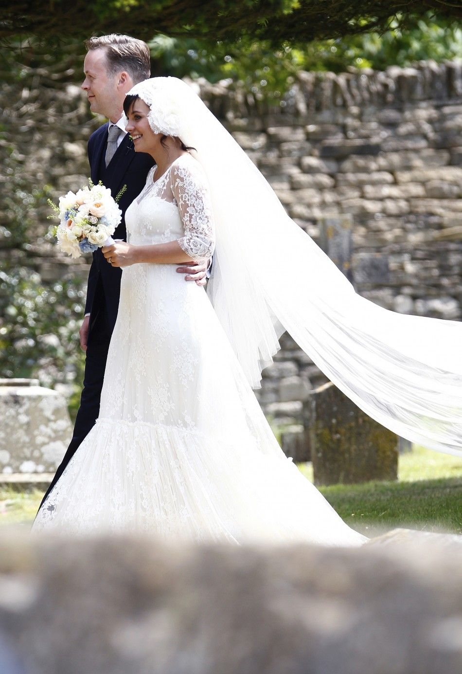 British singer Lily Allen R smiles after marrying Sam Cooper as the couple leaves St James the Great Church in Cranham, Goucestershire, western England, June 11, 2011.