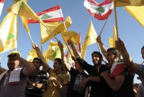 Supporters of Lebanon's Hezbollah wave Lebanese and Hezbollah flags as they listen to a televised address by Sayyed Hassan Nasrallah during a rally in Nabi sheet