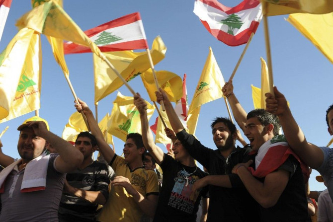 Supporters of Lebanon's Hezbollah wave Lebanese and Hezbollah flags as they listen to a televised address by Sayyed Hassan Nasrallah during a rally in Nabi sheet