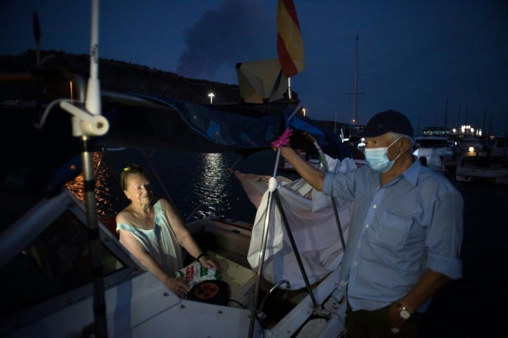 Pensioners Margaretha and Luis wait on their boat in the La Palma port of Tazacorte, where they fled following the eruption