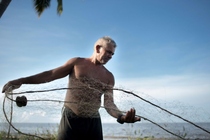 A fisherman prepares his net at Lake Maracaibo, Venezuela where an eight-year economic crisis has left people with shortages of food and fuel despite the country sitting on massive oil reserves