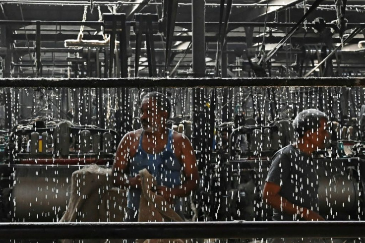 In this picture taken on March 19, 2021, labourers work at a private jute mill in Jagatdal. From the boutiques of Christian Dior to royal wedding favours, jute is growing in popularity worldwide as demand for alternatives to plastic soars, with experts pr
