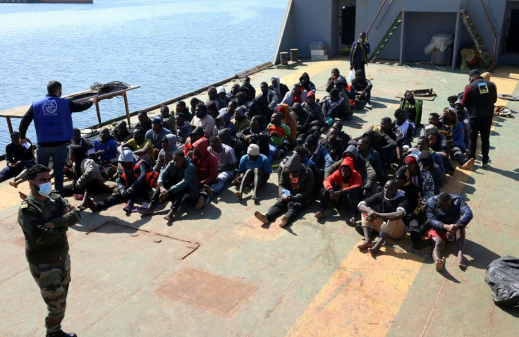 Rescued migrants sit aboard a Libyan coast guard vessel arriving at the capital Tripoli's naval base on February 28, 2021