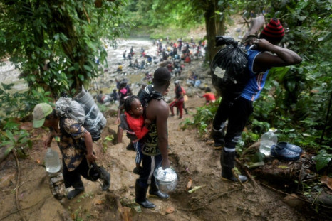Haitian migrants cross the jungle of the Darien Gap, near Acandi, Choco department, Colombia, heading to Panama, on September 26, 2021, on their way trying to reach the US. From Acandi, they started on foot -- and armed with machetes, lanterns and tents -