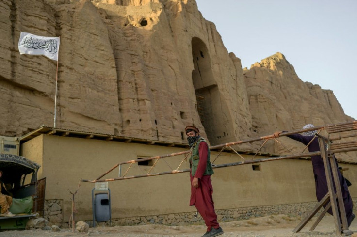 The Taliban fly their flag at the site where a Buddha statue once stood, before it was destroyed by the militants' former regime
