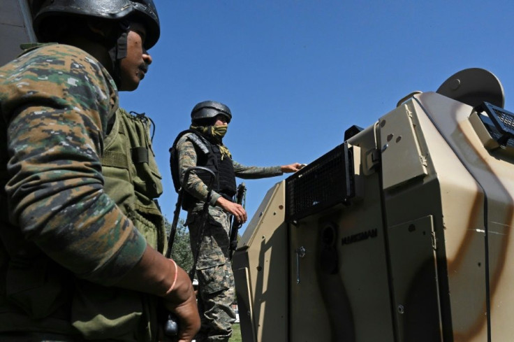 Indian paramilitary troops stand guard at the government-run school on the outskirts of Srinagar after the killings