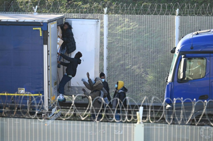 Migrants attempt to board a truck bound for Britain