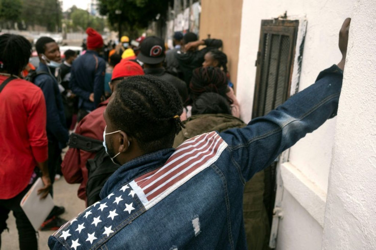 Haitian migrants queue to register with the Mexican Commission for Refugee Assistance in the border city of Tijuana