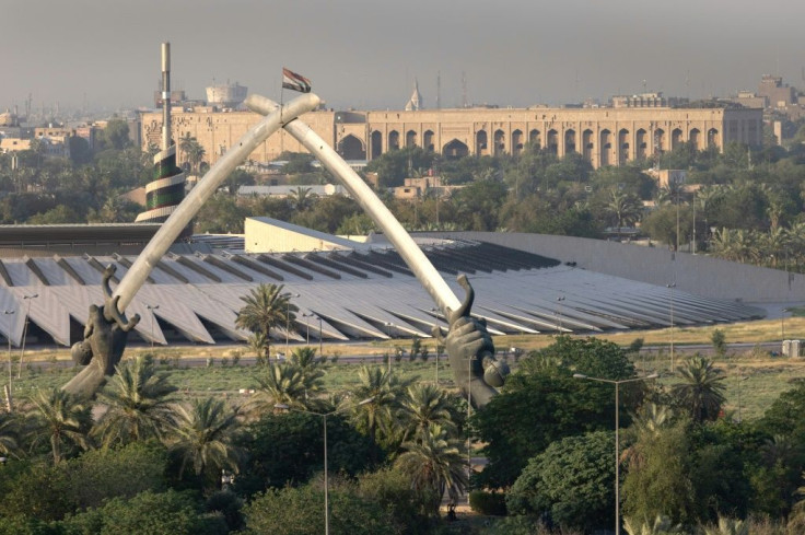 The Crossed Sabers monument and the Iraqi Tomb of the Unknown Soldier stand near a Saddam-era statue as seen from the International Zone in Baghdad