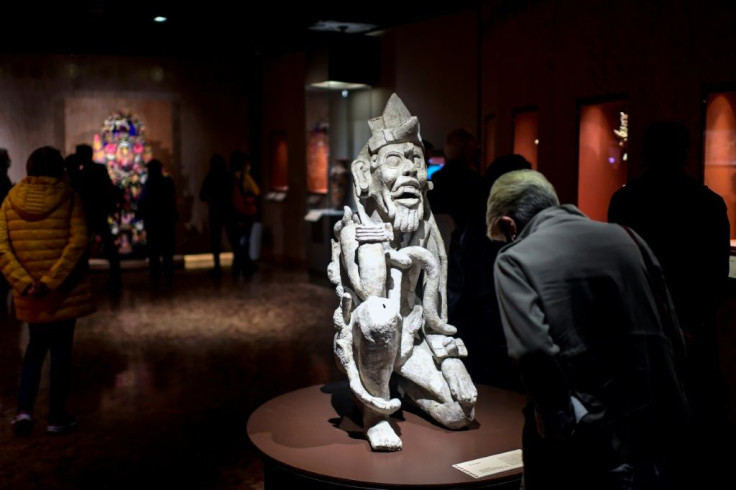 A visitor looks at a sculpture called "El Creador" at the "Greatness of Mexico" exhibition at the National Museum of Anthropology in the Mexican capital