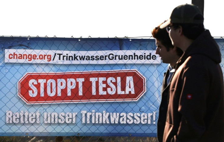 Signs protesting Tesla's new car factory were visible near the Tesla event